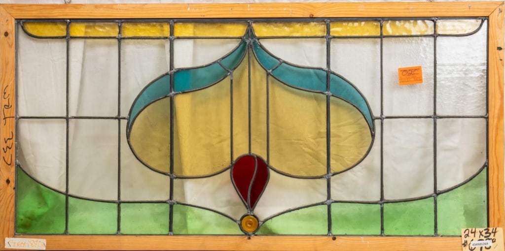 FRENCH ART NOUVEAU STAINED GLASS PANEL: French Art Nouveau stained glass panel with a heart-shaped medallion and blue, amber, and red details. Approximate dimensions: h. 24", w. 34" Disclaimer: This is an online court ordered bankruptcy sal