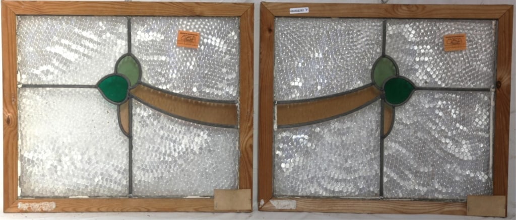 PAIR OF ANTIQUE CONTINENTAL STAINED GLASS PANELS: Pair of antique Continental stained glass panels with a symmetrical floral and garland motif in amber and green stained glass set within colorless leaded glass panels. Approximate dimensions: h. 20",