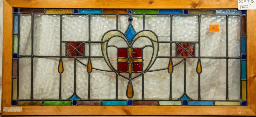 FRENCH ART NOUVEAU STAINED GLASS PANEL: French Art Nouveau stained glass panel with heart-shaped central medallion, red wispy glass accents to the sides, and amber glass drops. Approximate dimensions: h. 19.5", w. 23" Disclaimer: This is an