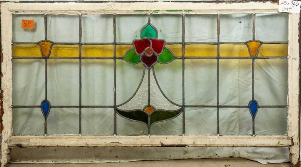 FRENCH ART NOUVEAU STAINED GLASS PANEL: French Art Nouveau stained glass panel with a floral central medallion and two symmetrical amber and blue accents on each side. Approximate dimensions: h. 25", w. 50.5" Disclaimer: This is an online c