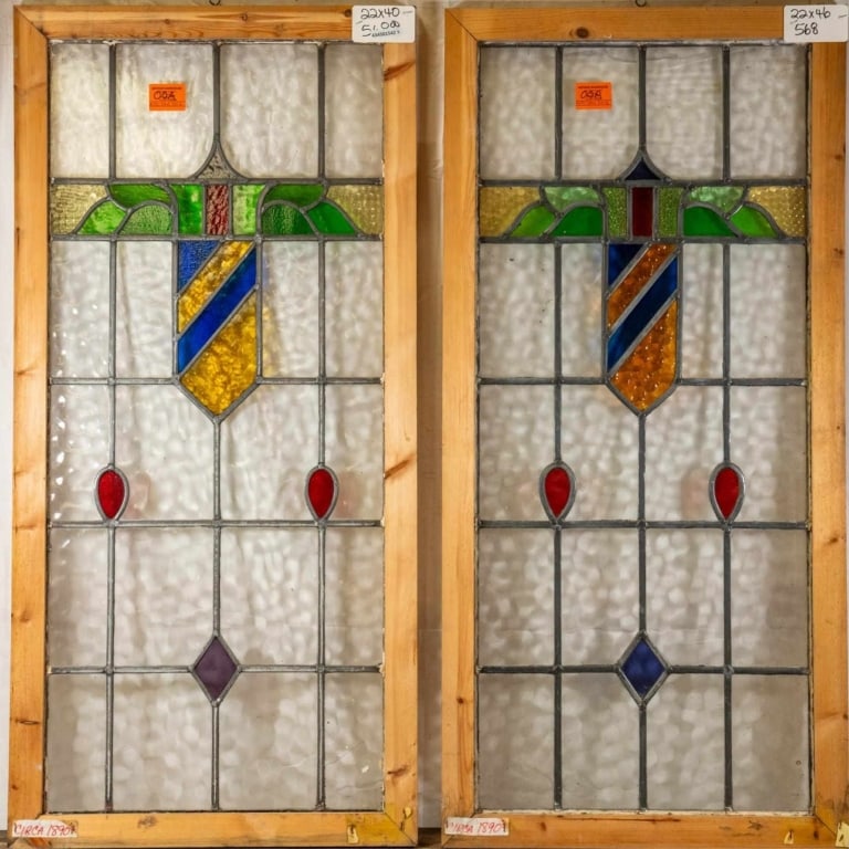 TWO CONTINENTAL STAINED GLASS PANELS: Two Continental stained glass panels with shield medallions, accented with lead elements and red and purple glass. Approximate dimensions: h. 46", w. 22" Disclaimer: This is an online court ordered ba