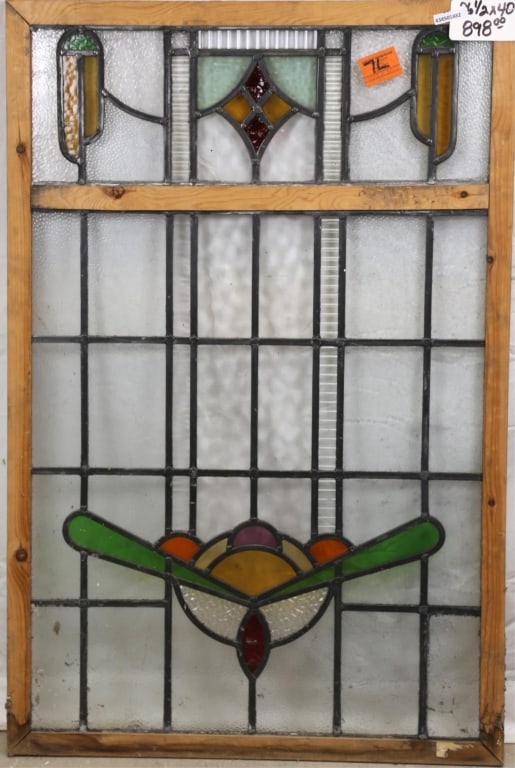 ANTIQUE ENGLISH STAINED GLASS PANEL: Antique English stained glass panel with floral medallion, yellow and red rhombic accent, and two symmetrical yellow and green details to the sides. Approximate dimensions: h. 40", w. 26.5" Disclaimer