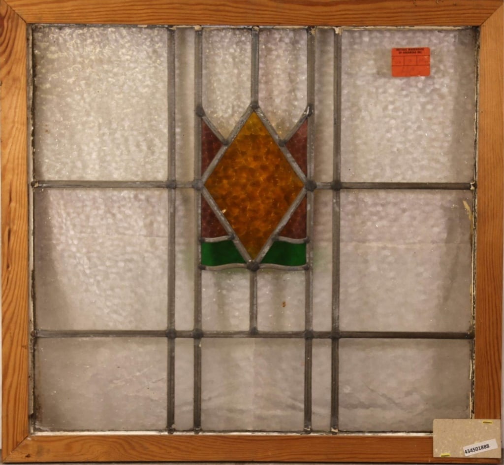 ANTIQUE ENGLISH STAINED GLASS PANEL: Antique English stained glass panel with geometric central medallion in purple, green, and amber stained glass. Approximate dimensions: h. 24", w. 26" Disclaimer: This is an online court ordered bankr