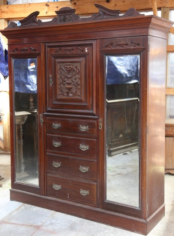 ENGLISH MAHOGANY WARDROBE: English mahogany wardrobe with a carved central panel, beveled mirrors, and a broken-arch pediment. Approximate dimensions: h. 89.5", w. 78", d. 23.5" Disclaimer: This is an online court ordered bankr