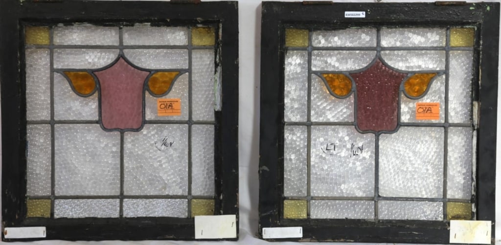 PAIR OF IRISH STAINED GLASS PANELS: Pair of Irish stained glass panels with a shield-form medallion in purple and amber stained glass. Approximate dimensions: h. 21", w. 20.5" Disclaimer: This is an online court ordered bankruptcy sale.