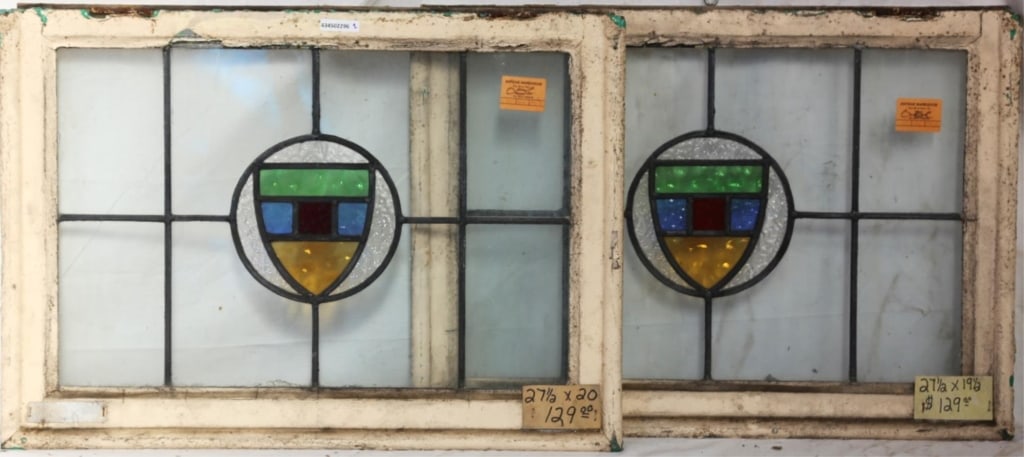 PAIR OF ENGLISH STAINED GLASS PANELS: Pair of English stained glass panels with shield-form medallions and multicolored stained glass accents. Approximate dimensions: h. 20", w. 27.5" Disclaimer: This is an online court ordered bankruptcy