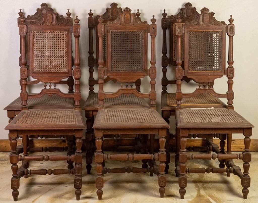 SET OF 6 FRENCH RENAISSANCE REVIVAL CHAIRS: Set of six French Renaissance Revival chairs with cane seats, deeply carved details, flanking finials, and a central carved crest. Approximate dimensions: h. 44", w. 18", d. 17" Disclaimer: This is an