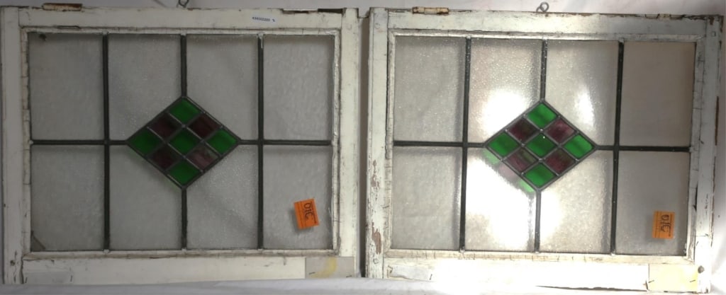 PAIR OF ANTIQUE IRISH STAINED GLASS PANELS: Pair of antique Irish stained glass panels with green and purple wispy glass geometric medallions. Approximate dimensions: h. 20.5", w. 25" Disclaimer: This is an online court ordered bankruptcy sale.