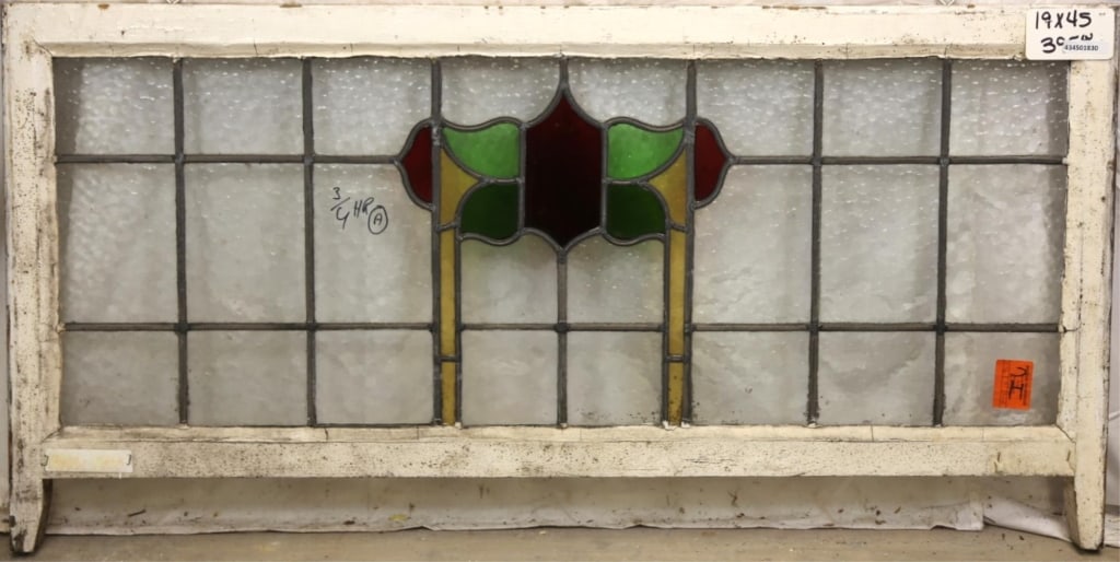 ANTIQUE IRISH STAINED GLASS PANEL: Antique Irish stained glass panel with red, green, and amber stained glass medallion. Approximate dimensions: h. 19", w. 45" Disclaimer: This is an online court ordered bankruptcy sale. Participating