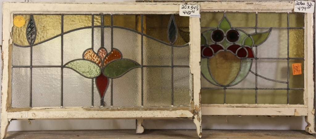 TWO FRENCH ART NOUVEAU STAINED GLASS PANELS: Two French Art Nouveau stained glass panels, one with floral medallions and purple drop wispy glass accents, the other with two red jeweled details and floral medallion. Approximate dimensions: h. 20"