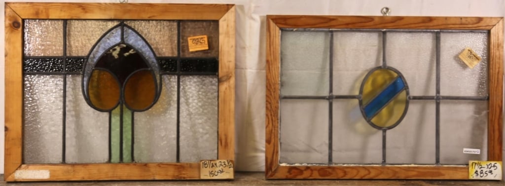 TWO ANTIQUE CONTINENTAL STAINED GLASS PANELS: Two antique Continental stained glass panels, one with a heart-shaped medallion and the other with an amber oval medallion with blue stripe. Approximate dimensions: h. 18.5", w. 23.5" Disclaimer: This