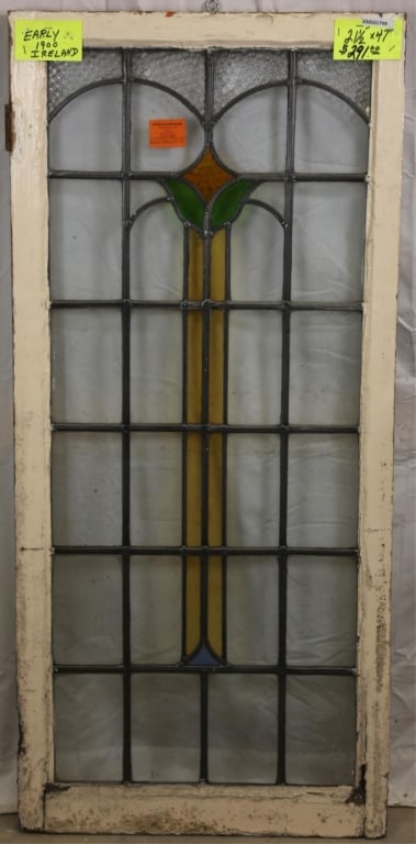 ANTIQUE IRISH STAINED GLASS PANEL: Antique Irish stained glass panel with amber, blue, green, and canary yellow details. Approximate dimensions: h. 47", w. 21.5" Disclaimer: This is an online court ordered bankruptcy sale. Participatin