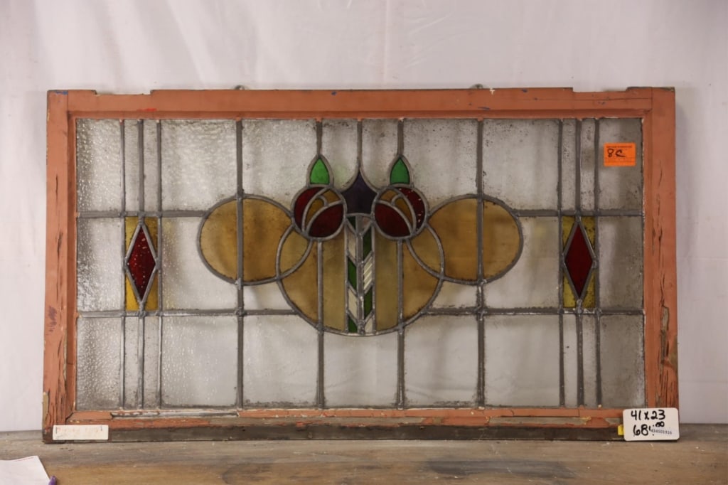 ANTIQUE CONTINENTAL STAINED GLASS PANEL: Antique Continental stained glass panel with floral and geometric medallion, red and yellow accents to the sides. Approximate dimensions: h. 21", w. 40" Disclaimer: This is an online court ordered ban