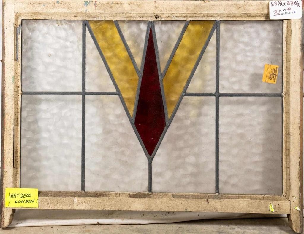 ENGLISH ART DECO STAINED GLASS PANEL: English Art Deco stained glass panel with amber and red stained glass accents. Approximate dimensions: h. 23.5", w. 33.5" Disclaimer: This is an online court ordered bankruptcy sale. Participating bid