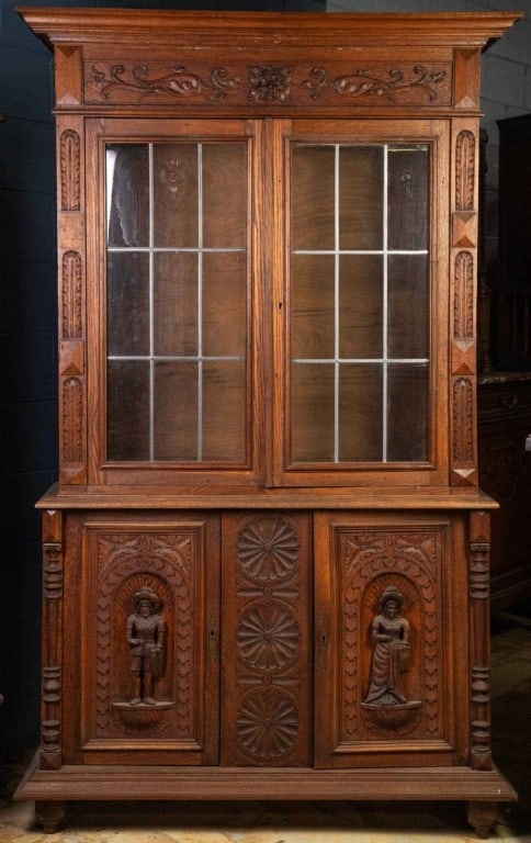 FRENCH RENAISSANCE REVIVAL LEADED GLASS BOOKCASE: French Renaissance Revival leaded glass bookcase with large figural carved appliqués and carved rosettes. Approximate dimensions: h. 78", w. 45", d. 14" Disclaimer: This is an online court ordered ba
