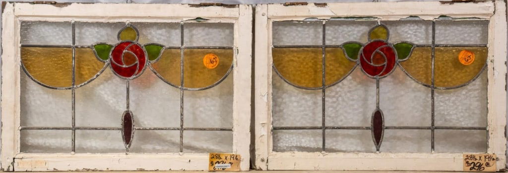 PAIR OF FRENCH ART NOUVEAU STAINED GLASS PANELS: Pair of French Art Nouveau stained glass panels with rose medallions and amber and purple glass details. Approximate dimensions: h. 19.5", w. 28.5" Disclaimer: This is an online court ordered bankrupt