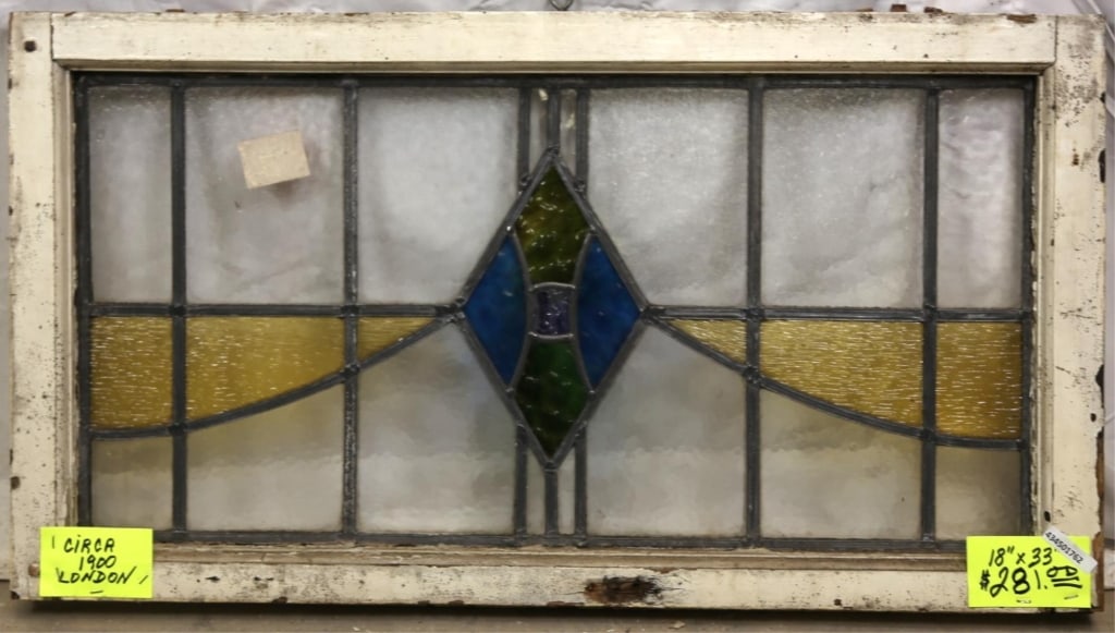 ENGLISH ART DECO STAINED GLASS PANEL: English Art Deco stained glass panel with textured rhombic green and blue medallions and amber accents. Approximate dimensions: h. 18", w. 33" Disclaimer: This is an online court ordered bankruptcy sa
