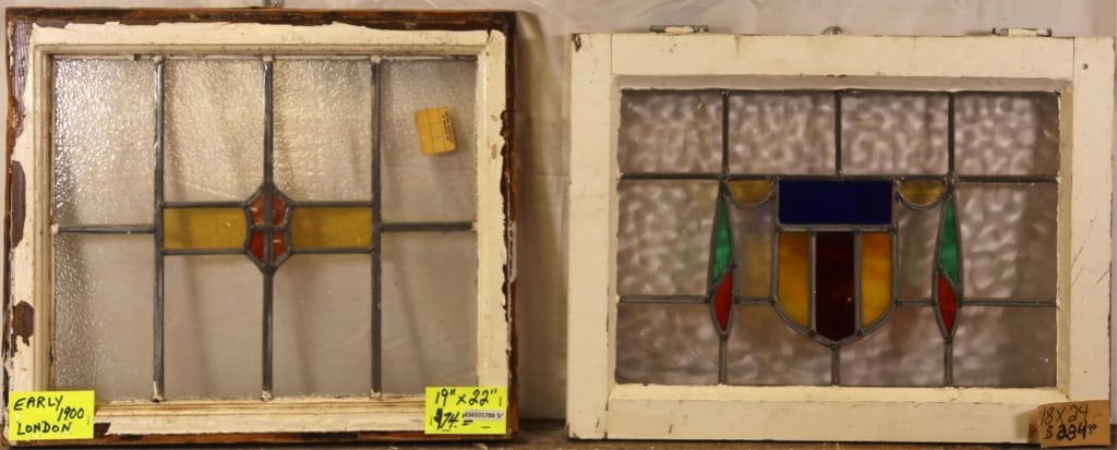 TWO ANTIQUE ENGLISH STAINED GLASS PANELS: Two antique English stained glass panels with shield-form medallions and textured and wispy glass elements. Approximate dimensions: h. 19", w. 22" Disclaimer: This is an online court ordered bankruptc