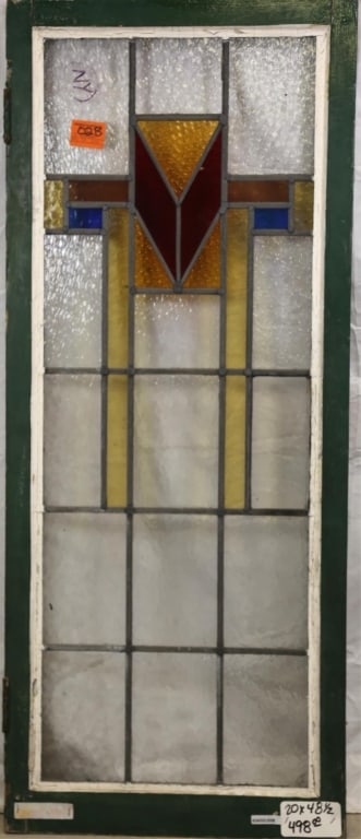 ENGLISH ART DECO STAINED GLASS PANEL: English Art Deco stained glass panel with geometric medallion in red, amber, and blue, and textured colorless leaded glass panels. Approximate dimensions: h. 48.5", w. 20" Disclaimer: This is an onlin