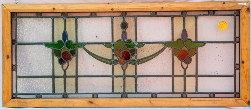 FRENCH ART NOUVEAU STAINED GLASS PANEL: French Art Nouveau stained glass panel with bright green, red, and canary stained glass details set within textured leaded glass panels. Approximate dimensions: h. 22", w. 55.25" Disclaimer: This is a