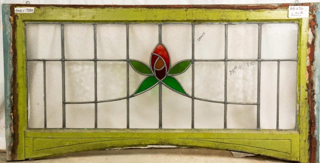 FRENCH ART NOUVEAU STAINED GLASS PANEL: French Art Nouveau stained glass panel with a red floral medallion, green leaf accents and colorless leaded glass panels. Approximate dimensions: h. 28", w. 56" Disclaimer: This is an online court ord