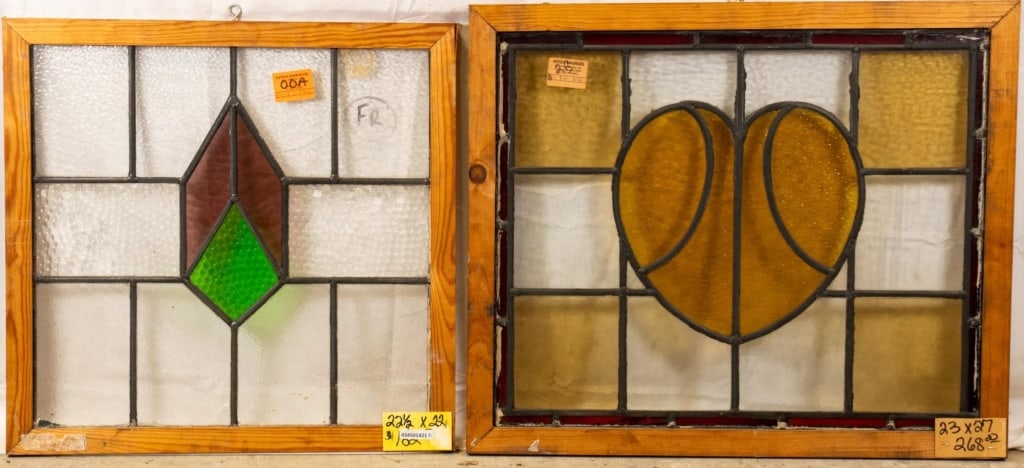 TWO CONTINENTAL STAINED GLASS PANELS: Two Continental Art Nouveau stained glass panels, one with an amber heart-shaped medallion, the other with a red and green geometric medallion. Approximate dimensions: h. 23", w. 27" Disclaimer: This