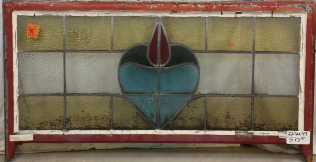FRENCH ART NOUVEAU STAINED GLASS PANEL: French Art Nouveau stained glass panel with heart-shaped floral motif medallion in blue, red, and green, and amber leaded glass panels. Approximate dimensions: h. 22.5", w. 47" Disclaimer: This is an