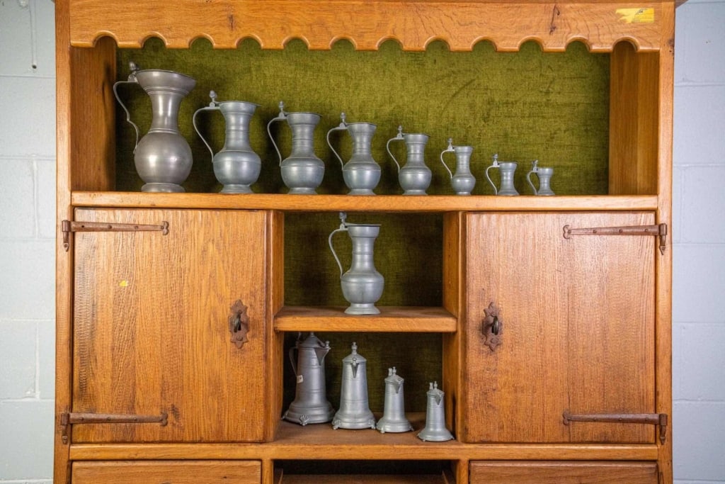 13 PEWTER WINE JUGS: Nine wine flagon pitchers with acorn accents, graduated in size, and four wine jugs of a different design, also graduated in size. Disclaimer: This is an online court ordered bankruptcy sale. Particip