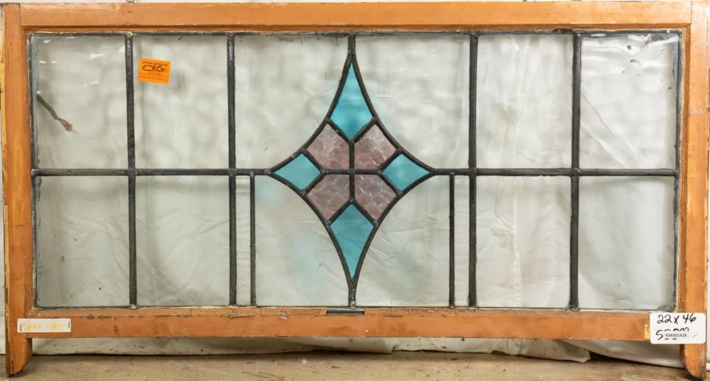 ANTIQUE ENGLISH STAINED GLASS PANEL: Antique English stained glass panel with blue and pink rhombic medallion. Approximate dimensions: h. 22", w. 46" Disclaimer: This is an online court ordered bankruptcy sale. Participating bidders must