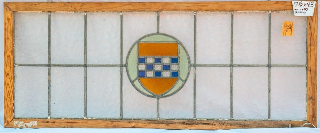 IRISH STAINED GLASS PANEL: Irish stained glass panel with a shield medallion. Approximate dimensions: h. 17.5", w. 43" Disclaimer: This is an online court ordered bankruptcy sale. Participating bidders must have a credit card o