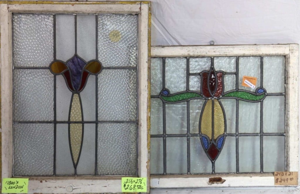 TWO ENGLISH STAINED GLASS PANELS: Two English stained glass panels, one with a floral motif medallion and purple wispy glass detail, and the other with a multicolored floral motif medallion. Approximate dimensions: h. 27.5", w. 21.5"