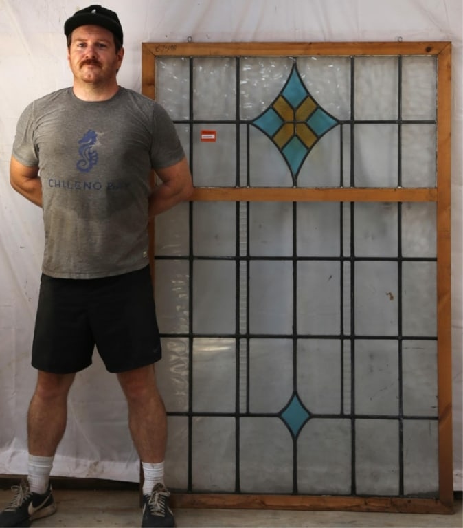 ANTIQUE CONTINENTAL STAINED GLASS PANEL: Antique Continental stained glass panel with blue and yellow rhombic medallion and colorless leaded glass panels. Approximate dimensions: h. 63", w. 41.5" Disclaimer: This is an online court ordered b