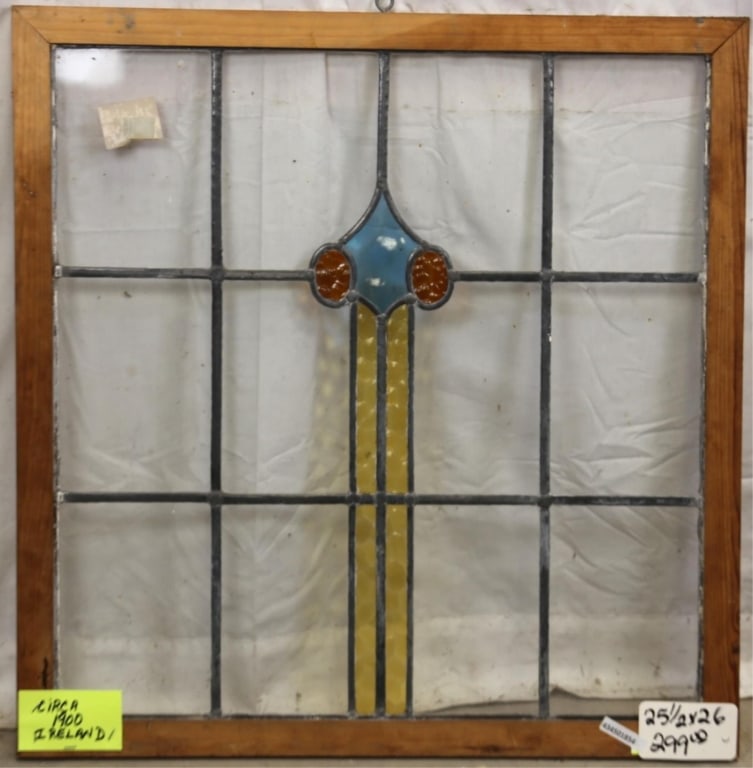 ANTIQUE IRISH STAINED GLASS PANEL: Antique Irish stained glass panel with amber, yellow, and blue medallion and colorless leaded glass panels. Approximate dimensions: h. 25.5", w. 26" Disclaimer: This is an online court ordered bankrup