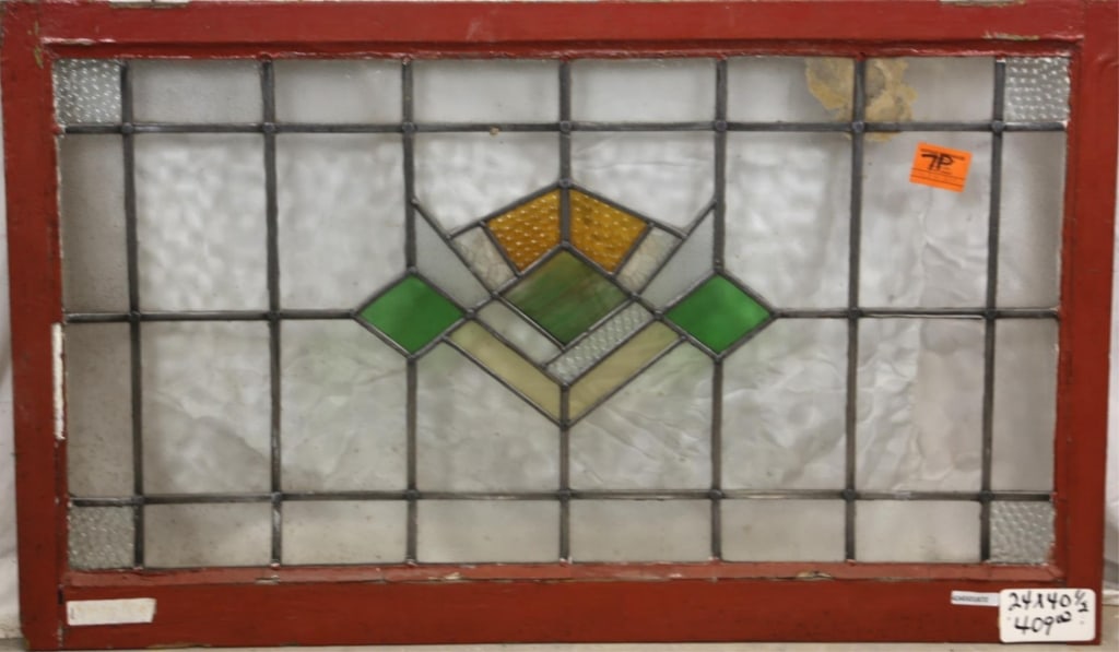 ENGLISH ART DECO STAINED GLASS PANEL: English Art Deco stained glass panel with geometric medallion, wispy glass green details, and textured amber accents. Approximate dimensions: h. 24", w. 40.5" Disclaimer: This is an online court order