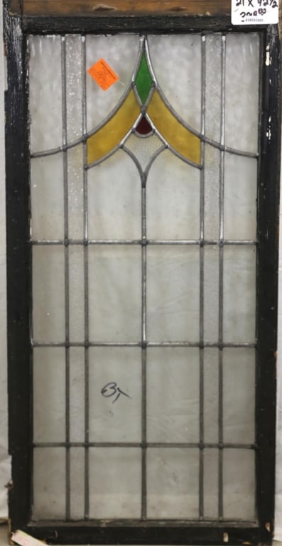 ENGLISH ART DECO STAINED GLASS PANEL: English Art Deco stained glass panel with geometric medallion in yellow, red, and green, and textured colorless leaded panels. Approximate dimensions: h. 42.5", w. 21" Disclaimer: This is an online co
