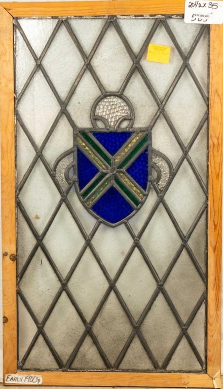 ENGLISH STAINED GLASS PANEL: English stained glass panel with shield-shaped medallion and blue textured glass details. Approximate dimensions: h. 35", w. 20.5" Disclaimer: This is an online court ordered bankruptcy sale. Particip