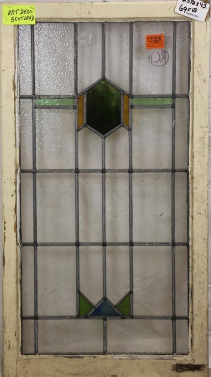 SCOTTISH ART DECO STAINED GLASS PANEL: Scottish Art Deco stained glass panel with geometric medallion and green wispy glass accent. Approximate dimensions: h. 43", w. 23.5" Disclaimer: This is an online court ordered bankruptcy sale. Parti