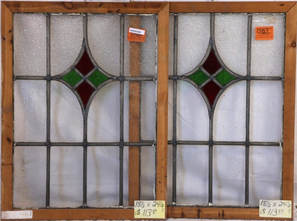 PAIR OF CONTINENTAL STAINED GLASS PANELS: Pair of Continental stained glass panels with rhombic green and red medallions and textured colorless leaded glass panels. Approximate dimensions: h. 24.5", w. 18.5" Disclaimer: This is an online cour