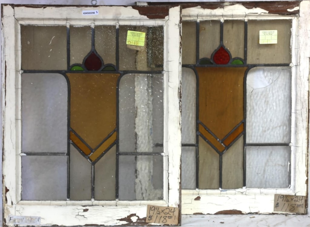 PAIR OF ANTIQUE CONTINENTAL STAINED GLASS PANELS: Pair of antique Continental stained glass panels with an amber, red, and green medallions with floral elements. Approximate dimensions: h. 24", w. 19.5" Disclaimer: This is an online court ordered ban