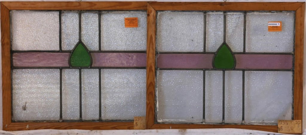 PAIR OF ENGLISH STAINED GLASS PANELS: Pair of English stained glass panels with green and purple stained glass accents set within colorless leaded glass panels. Approximate dimensions: h. 20.5", w. 23" Disclaimer: This is an online court