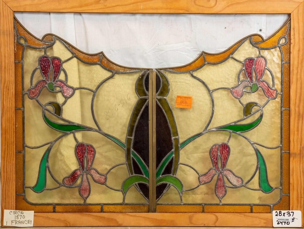 FRENCH ART NOUVEAU STAINED GLASS PANEL: French Art Nouveau stained glass panel with pink orchid elements, a carved top, and amber garland and green leaf motifs. Approximate dimensions: h. 28", w. 37" Disclaimer: This is an online court orde