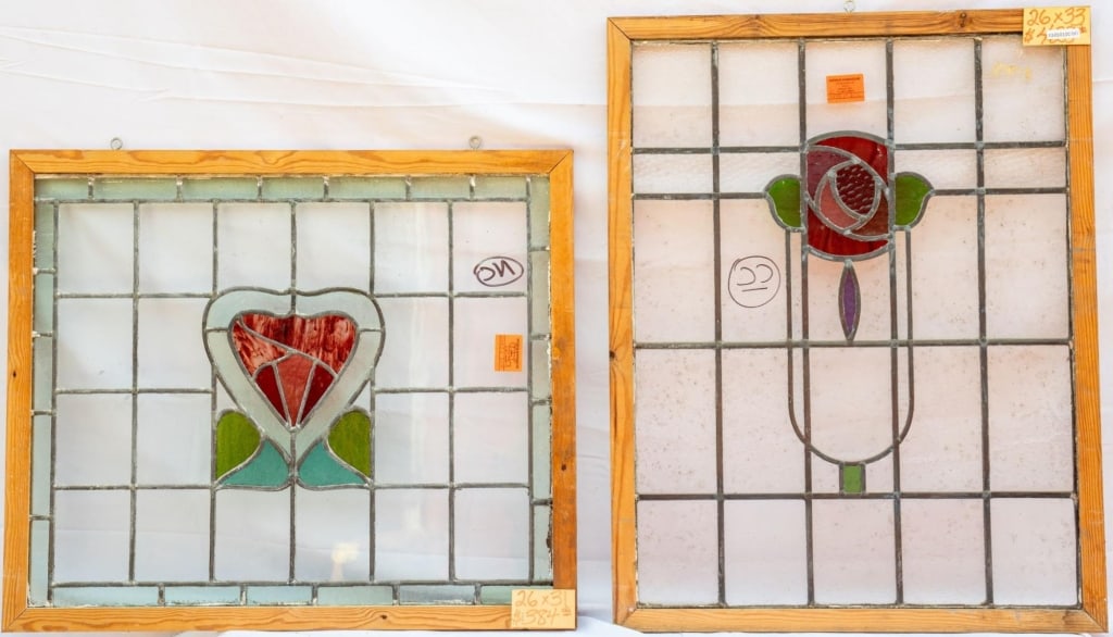 TWO FRENCH STAINED GLASS PANELS: Two French stained glass panels with heart and floral stained glass inset. Approximate dimensions: h. 26", w. 33" Disclaimer: This is an online court ordered bankruptcy sale. Participating bidders mus