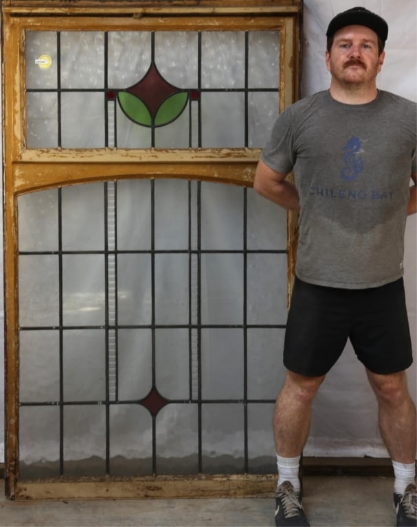 ANTIQUE CONTINENTAL STAINED GLASS PANEL: Antique Continental stained glass panel with red and green geometric motif medallion and colorless leaded glass panels. Approximate dimensions: h. 69", w. 41" Disclaimer: This is an online court order