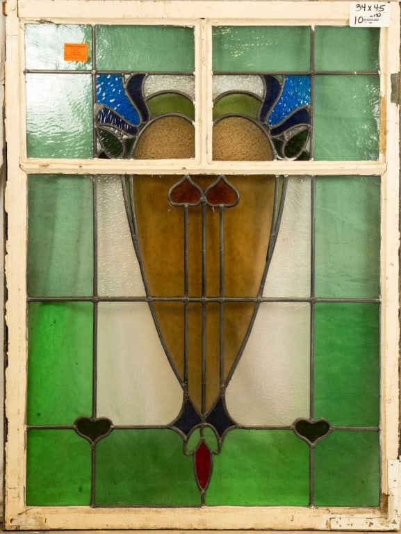 FRENCH ART NOUVEAU STAINED GLASS PANEL: French Art Nouveau stained glass panel with a heart-shaped floral medallion and textured blue, green, and amber accents. Approximate dimensions: h. 45", w. 34" Disclaimer: This is an online court orde