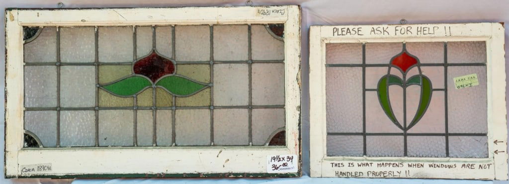 TWO FRENCH ART NOUVEAU STAINED GLASS PANELS: Two French Art Nouveau stained glass panels with leaded glass panels accented with red and green floral motifs. Approximate dimensions: h. 19.5", w. 34" Disclaimer: This is an online court ordered ban