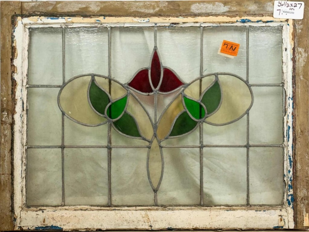 ANTIQUE ENGLISH STAINED GLASS PANEL: Antique English stained glass panel with a red floral medallion, green leaf accents, and colorless leaded glass panels. Approximate dimensions: h. 27", w. 36.5" Disclaimer: This is an online court ord