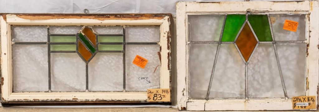 TWO CONTINENTAL STAINED GLASS PANELS: Two Continental stained glass panels with shield-shaped and geometric medallions. Approximate dimensions: h. 14.5", w. 26" Disclaimer: This is an online court ordered bankruptcy sale. Participating bi