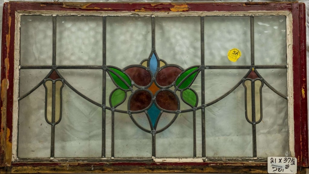 FRENCH ART NOUVEAU STAINED GLASS PANEL: French Art Nouveau stained glass panel with central floral medallion and symmetrical amber and purple accents on each side. Approximate dimensions: h. 21", w. 37.5" Disclaimer: This is an online court