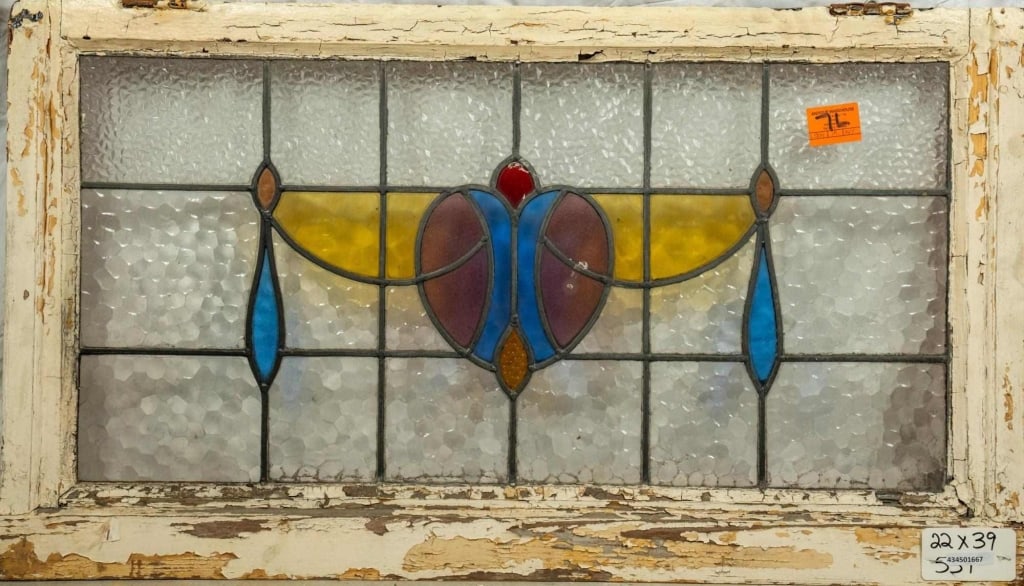 FRENCH ART NOUVEAU STAINED GLASS PANEL: French Art Nouveau stained glass panel with heart-shaped medallion, garland motif, and blue and amber accents. Approximate dimensions: h. 22", w. 39" Disclaimer: This is an online court ordered bankru