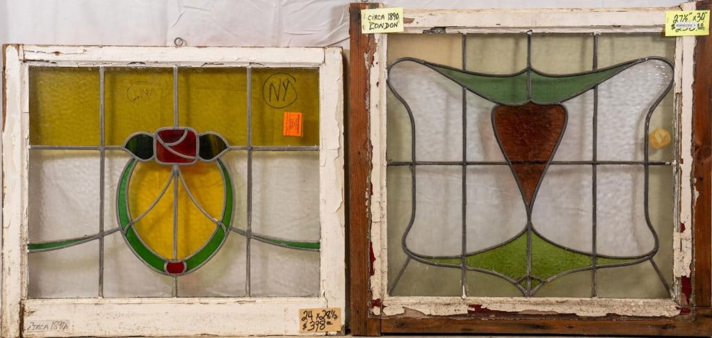 TWO CONTINENTAL STAINED GLASS PANELS: Two Continental stained glass panels, one with a floral medallion and the other with red, chartreuse, and green abstract details. Approximate dimensions: h. 27.5", w. 30" Disclaimer: This is an online